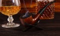 On the table are a decanter and a glass of whiskey and a smoking pipe Royalty Free Stock Photo