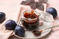 Glass jar with delicious homemade plum jam on table