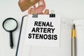 On the table there is a magnifying glass and a notepad with the inscription - Renal artery stenosis