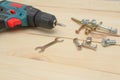 Electric screwdriver on a wooden table. Side view of the black metallic screws, electric screwdriwer on the wodden boards