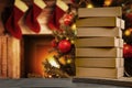 Christmas decorations and gift boxes, parcels with blurred christmas tree and fireplace background.