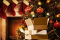 Christmas decorations and gift boxes, parcels with blurred christmas tree and fireplace background.