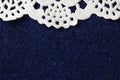 WHITE DECORATIVE PAPER DOILY ON BLUE DENIM CLOTH BACKGROUND