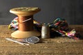 BROWN THREAD ON WOODEN COTTON REEL WITH NEEDLES, COLORED THREADS AND THIMBLE Royalty Free Stock Photo