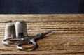 SMALL SILVER COLORED SCISSORS AND TWO METAL THIMBLES