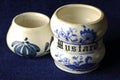 OLD GLAZED CERAMIC WHITE AND BLUE MUSTARD POT WITH SECOND SMALL DECORATED POT Royalty Free Stock Photo