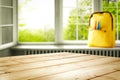 Wooden table top space for your products and a schoolbag in the classroom background. Some school accessories on windowsill.