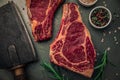 Table top of two pieces of uncooked bloody meat with cleaver knife