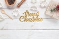 Table top view aerial image of Gold Merry Christmas text with cooking accessories.