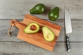 Table top view - avocado cut in half on wooden chopping board, c
