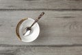 Table top view on small empty porcelain bowl with silver decorated spoon, placed on gray wood desk. Royalty Free Stock Photo