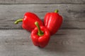 Table top view on three red bell peppers on a gray wood desk. Royalty Free Stock Photo