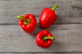 Table top view - three red bell peppers on gray wood desk. Royalty Free Stock Photo