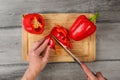 Table top view, woman hands holding chef knife cutting red bell Royalty Free Stock Photo