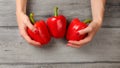 Table top view, woman hands holding three red bell peppers on gr Royalty Free Stock Photo