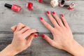 Table top view on young woman hands, applying second coat of red Royalty Free Stock Photo