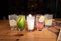 a table topped with five glasses of beverages and a newspaper