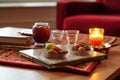 A table topped with a tray of dates food next to a candle