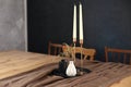 On table with tray are candles in candlesticks and a vase of flowers in room. Cozy home interior decor. Royalty Free Stock Photo