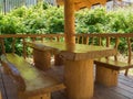 A table and two benches made of large solid wood in log cabin