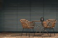 Table with two chairs on a terrace in front of blinds. Urban or industrial style Royalty Free Stock Photo