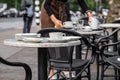 A table with uncleared dishes after visitors in a street cafe with a waitress in the background