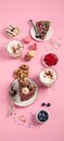 Table with various cookies, donuts, cakes, coffee cups on pink background Royalty Free Stock Photo