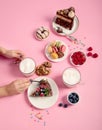 Table with various cookies, donuts, cakes, coffee cups on pink background Royalty Free Stock Photo