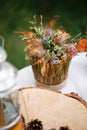 bouquet of dried small flowers, brown feathers and green leaves. Lead on the earth circle.