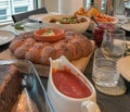 Table with vegan food: bread, salads, various sauces fruits, nuts, at a meeting of friends