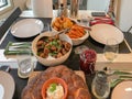 table with vegan food: bread, salads, various sauces fruits, nuts, at a meeting of friends