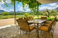 Table in vine-covered pavillion next to magnificent mountains