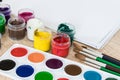 On the table are watercolor paints, brushes and gouache paints. Set for drawing, creativity and hobbies Royalty Free Stock Photo