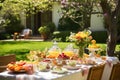 a table with a white table cloth and yellow chairs, A vibrant Easter brunch table spread against a backdrop of a sunny garden Royalty Free Stock Photo