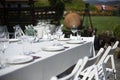 A table with white clothe glasses and chairs Royalty Free Stock Photo