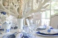 table with a white coral chandelier above, bluewhite porcelain, and pearl napkin rings