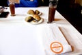 Table with white tablecloth, food and drink with cutlery labeled `clean and safe`