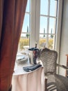 Table with white tablecloth, plates, napkins and ice cooler with dark glass bottle of wine