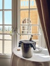 Table with white tablecloth, plates, napkins and ice cooler with dark glass bottle of wine