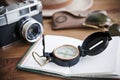 Table whith notebook, vintage camera, compass, sunglasses and hat. Royalty Free Stock Photo