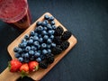 Fresh smothie made with blueberries, strawberries and blackberries with some forest fruits on a table