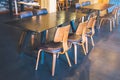 Table and wooden chairs in a modern coffee shop. Royalty Free Stock Photo