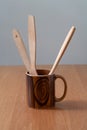 On the table is a wooden mug with wooden spoons. Royalty Free Stock Photo