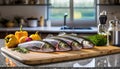 A selection of fresh fish: trout, sitting on a chopping board against blurred kitchen background copy space