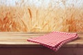 Tablecloth on wooden table over wheat field