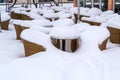 Tables and chairs in front of restaurant buried in snow