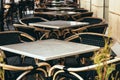 Tables and chairs in outdoor coffee or restauran terrace. Empty cafe in the pedestrian street in Europe.