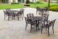 Tables and chairs on sandstone flooring at garden