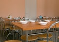 tables and chairs in the school dining room white bowls with lunch on the table