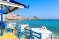 Tables with chairs in traditional Greek tavern in Kokkari town on coast of Samos island, Greece Royalty Free Stock Photo